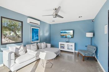 A living room with a white couch and a ceiling fan.
